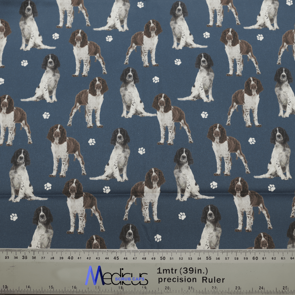 The Springer Spaniel Dogs Blue Scrub Cap by Medicus Scrub Caps features brown and white spaniels with paw prints on a dark blue background, combining style and function.