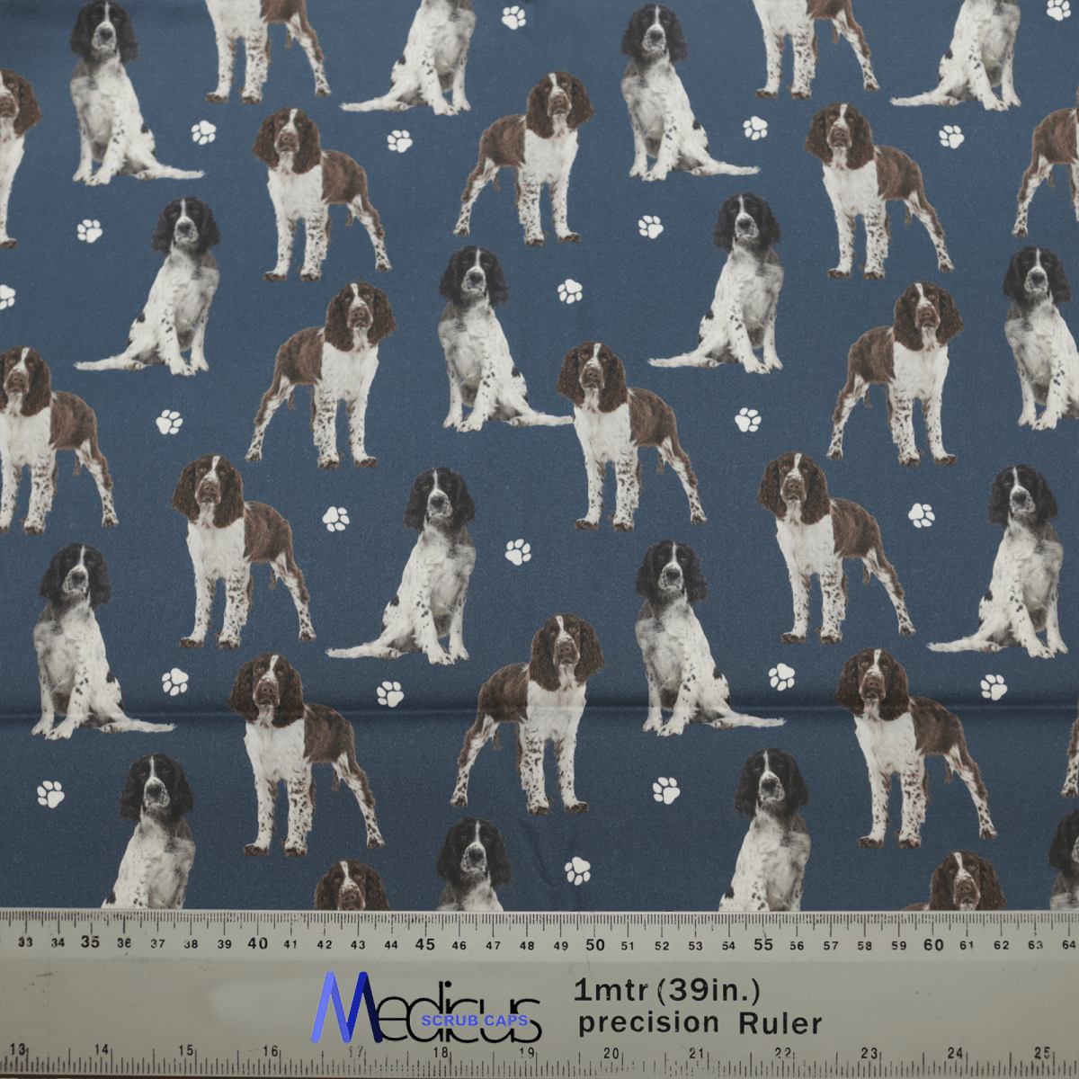 The Springer Spaniel Dogs Blue Scrub Cap by Medicus Scrub Caps features brown and white spaniels with paw prints on a dark blue background, combining style and function.
