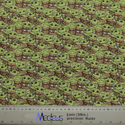 Patterned fabric with a small green alien in a brown robe and white scarf adds intergalactic charm. A 1-meter precision ruler shown for scale. Ideal for making a Star Wars Baby Yoda Crowd Scrub Cap by Medicus Scrub Caps with style.