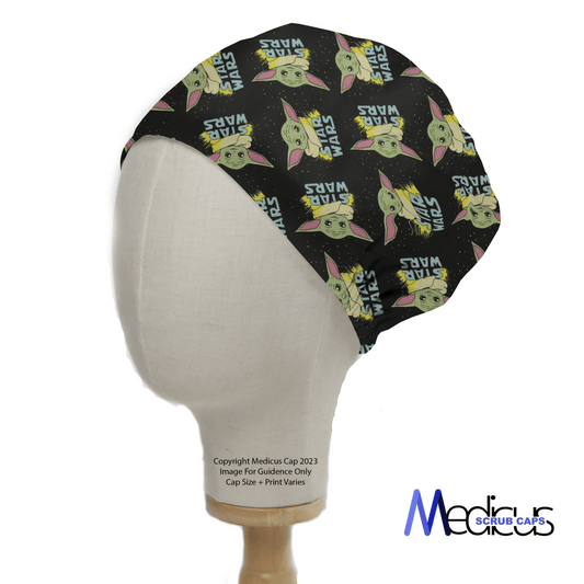 A side view of a mannequin head showcases the Star Wars Baby Yoda Profile Scrub Cap by Medicus Scrub Caps, featuring cartoon images of the green character with large ears on a black background, and the brand logo in the bottom right.