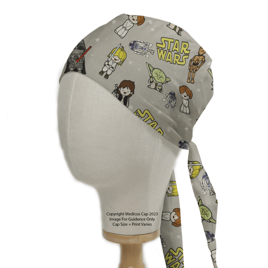 The mannequin head displays a Star Wars Original Kawaii Scrub Cap by Medicus Scrub Caps, featuring cartoon characters including robots, aliens, and humans on a light background.