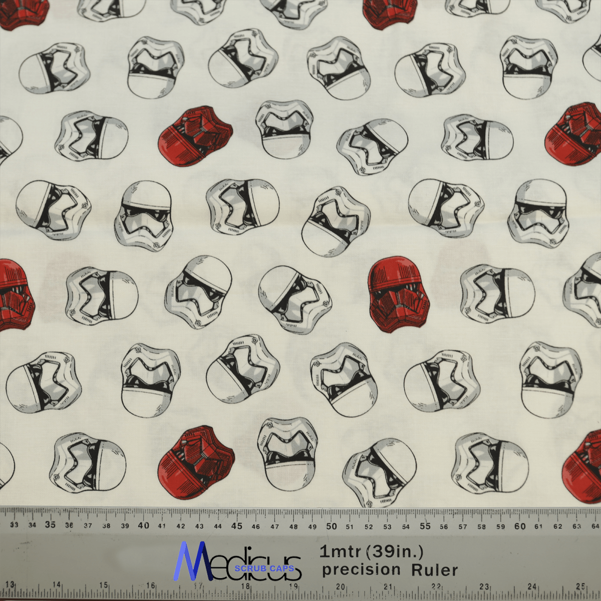 The Star Wars Stormtrooper Heads White Red Scrub Cap by Medicus Scrub Caps features black, white, and red helmets on a light fabric, with a ruler for measurements.