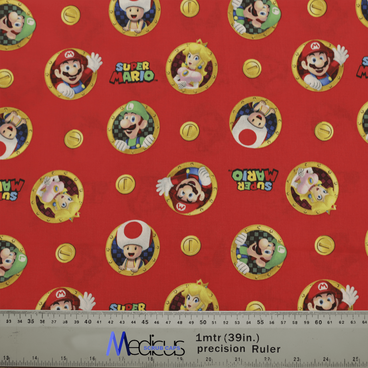 This Super Mario #1 fabric by Medicus Scrub Caps showcases circular portraits of classic video game characters, including a red plumber, green friend, and blonde princess. Yellow coins complete this lively design, ideal for crafting your own Video Game Scrub Cap. A ruler is faintly seen at the bottom.