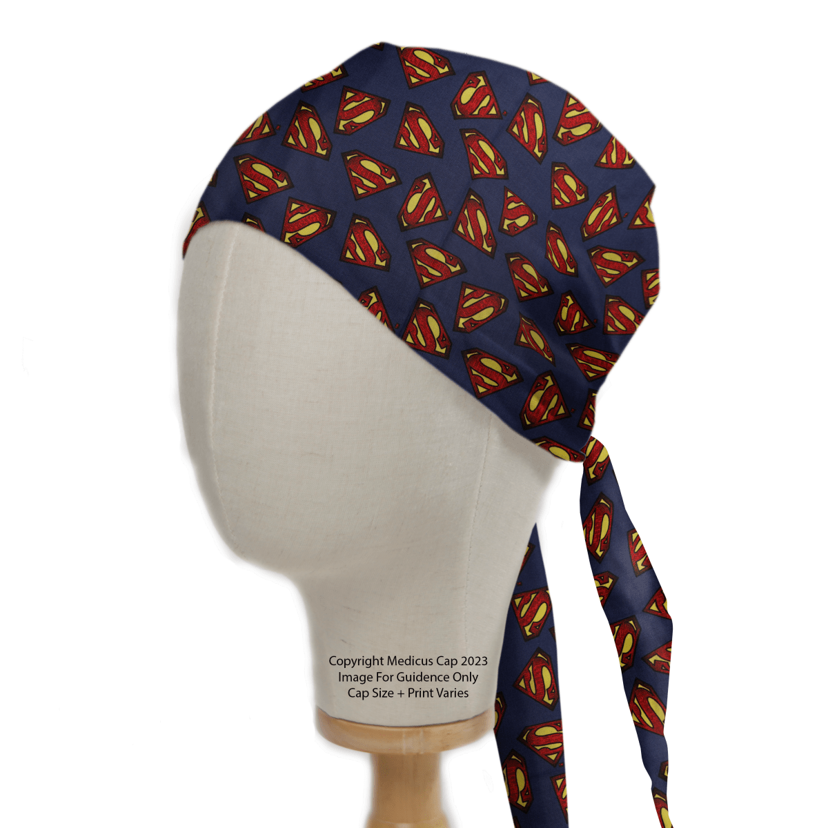 The mannequin head showcases a Medicus Scrub Caps Superman Logo On Navy Scrub Cap, featuring an eco-friendly design with a vibrant logo and a long tie-back strap.