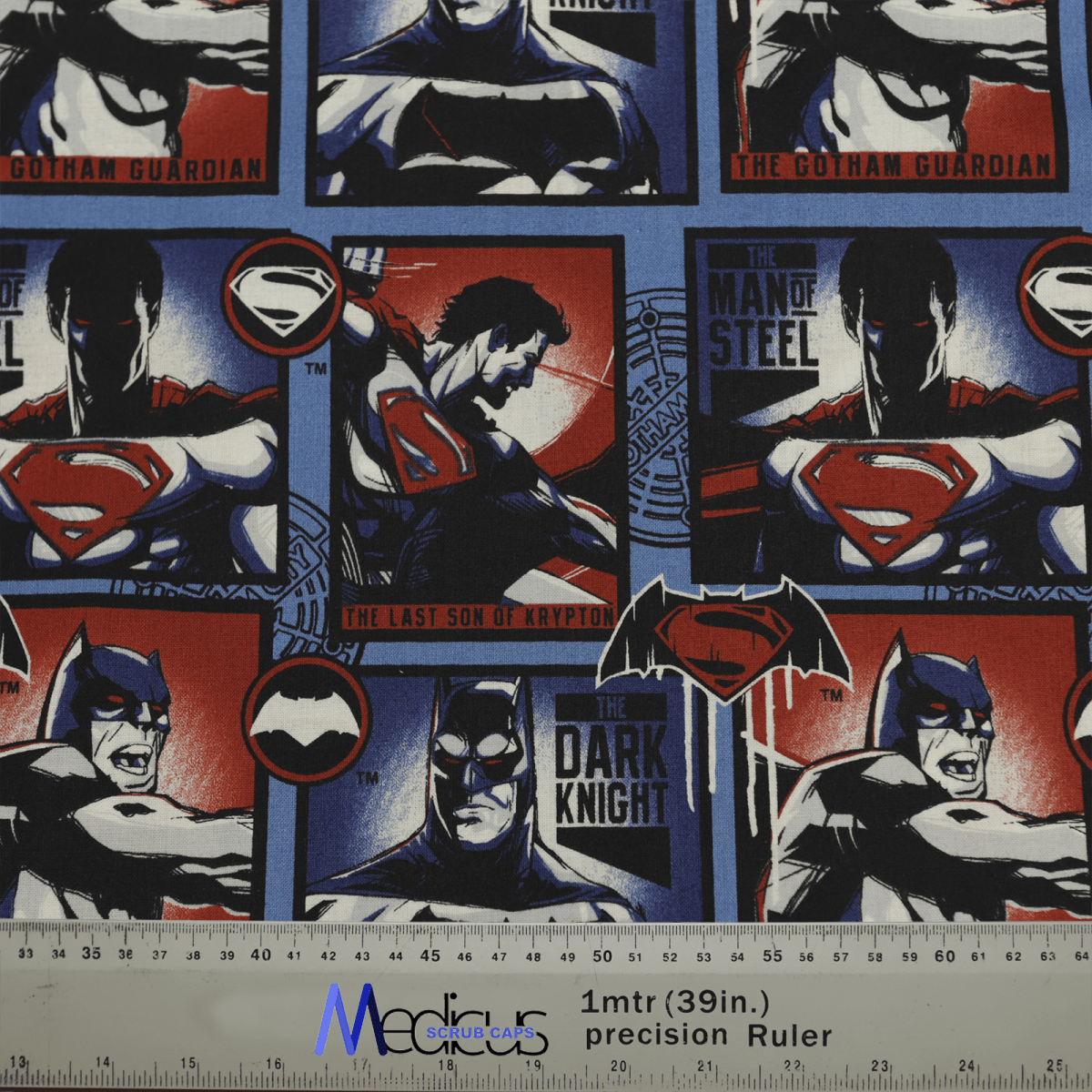 The Superman vs Batman #2 Scrub Cap by Medicus Scrub Caps is made from sustainable fabric and features stylized comic panels of The Last Son of Krypton and The Dark Knight. It showcases a dynamic clash in blue, red, and black with a ruler at the bottom for scale.