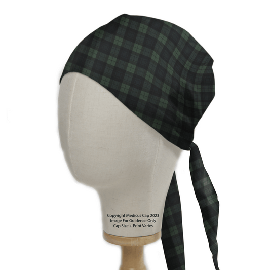 A side view of a mannequin head displays the Medicus Scrub Caps Tartan Green Blue Small Squares Scrub Cap, featuring long back ties. Showcased on a wooden stand, this reusable cap is in a classic checkered design with visible copyright notice on the front.