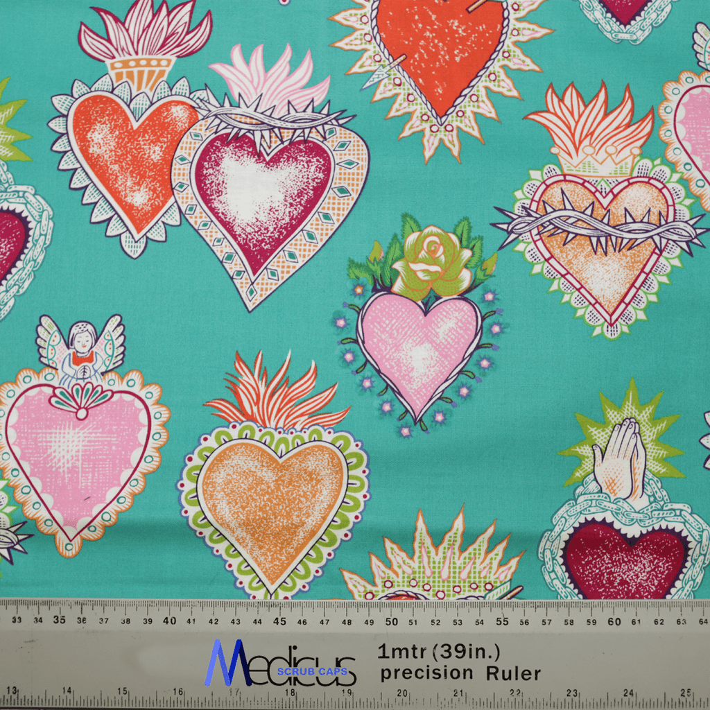 The Tattoo #1 Love Hearts Scrub Cap by Medicus Scrub Caps features a colorful tattoo art style pattern with Sacred Hearts, crowns, flames, and floral elements on a teal background. A precision ruler at the bottom reads 1mtr (39in.) precision Ruler and Marcus Fabrics.