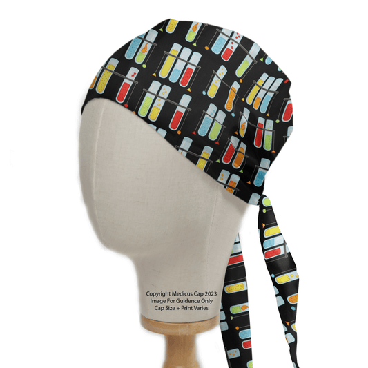 A mannequin head displays the Medicus Scrub Caps Test Tube Party Scrub Cap against a black background, featuring vibrant test tube and thermometer patterns. This playful, functional science workwear ties at the back and is shown under bright lighting on a plain mannequin.