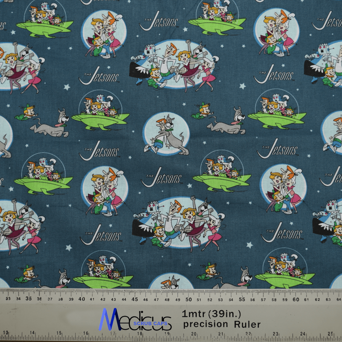 The Jetsons Family Scrub Cap by Medicus Scrub Caps boasts a retro-futuristic design, featuring cartoon scenes of the Jetsons Family and their dog in flying cars, with moons and stars adding whimsy. A ruler on the bottom offers measurements, making it reusable and perfect for any fan.