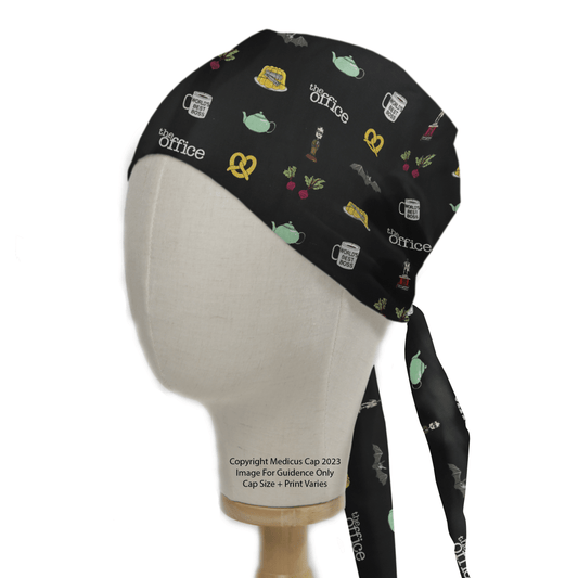 The Medical Scrub Caps brand presents The Office Trinkets Scrub Cap in black, offering a secure and comfy fit. It features iconic items like Worlds Best Boss mug, teapot, pretzel, beet, stapler in Jello, and a Dundie Award. Displayed on a mannequin head.