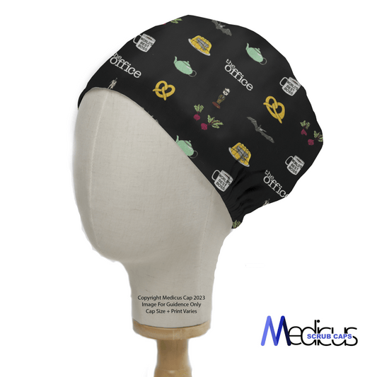 The Office Trinkets Scrub Cap by Medicus features icons from The Office, like a teapot, pretzel, and beet, on a black background. Displayed on a mannequin head, it highlights the designs comfortable and secure fit with visible branding.