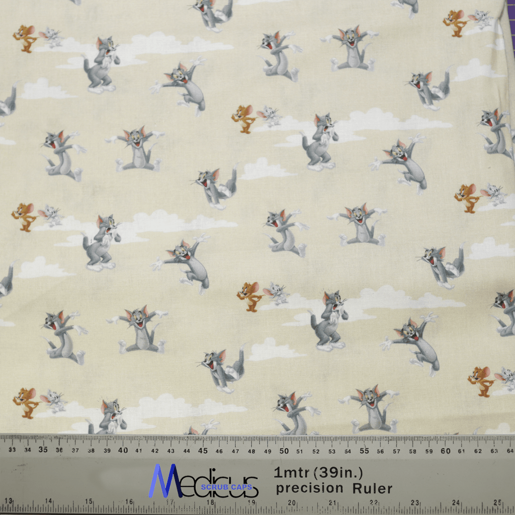 The Tom And Jerry Clouds Beige Scrub Cap by Medicus Scrub Caps features a playful pattern of cartoon cats and mice on a light background with clouds, and includes measurement markings in both inches and centimeters.