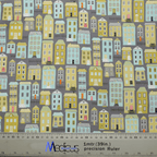 The Townhouse Scrub Cap by Medicus Scrub Caps is adorned with pastel-colored house illustrations on a gray background. Featuring a ruler for measurements in meters and inches, this charming cap is perfect for healthcare professionals seeking sustainable, reusable options.