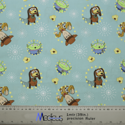 The Toy Story Woody Slink Aliens Scrub Cap by Medicus Scrub Caps features a light blue fabric with playful cartoon characters, including a springy brown dog, cowboy, and green alien. Ideal for healthcare professionals, it includes whimsical starburst accents and a precision ruler for scale.