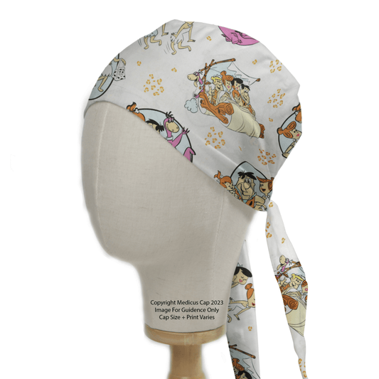 The Medicus Scrub Caps TV Cartoon Flintstones Bedrock Car Scrub Cap, shown on a mannequin head, features playful cartoon prints on a white background with colorful designs of animals, people, and the Flintstones car.