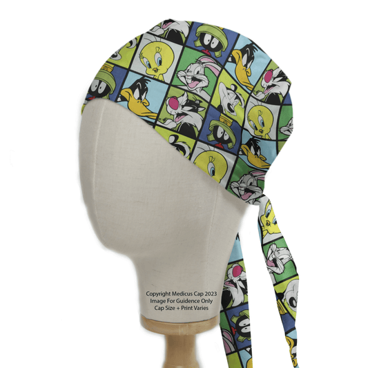 A mannequin head showcases the Medicus Scrub Caps eco-friendly TV Cartoon Looney Tunes Characters Grid Green Scrub Cap, featuring vibrant cartoon faces against blue, green, and yellow backgrounds for a playful charm.