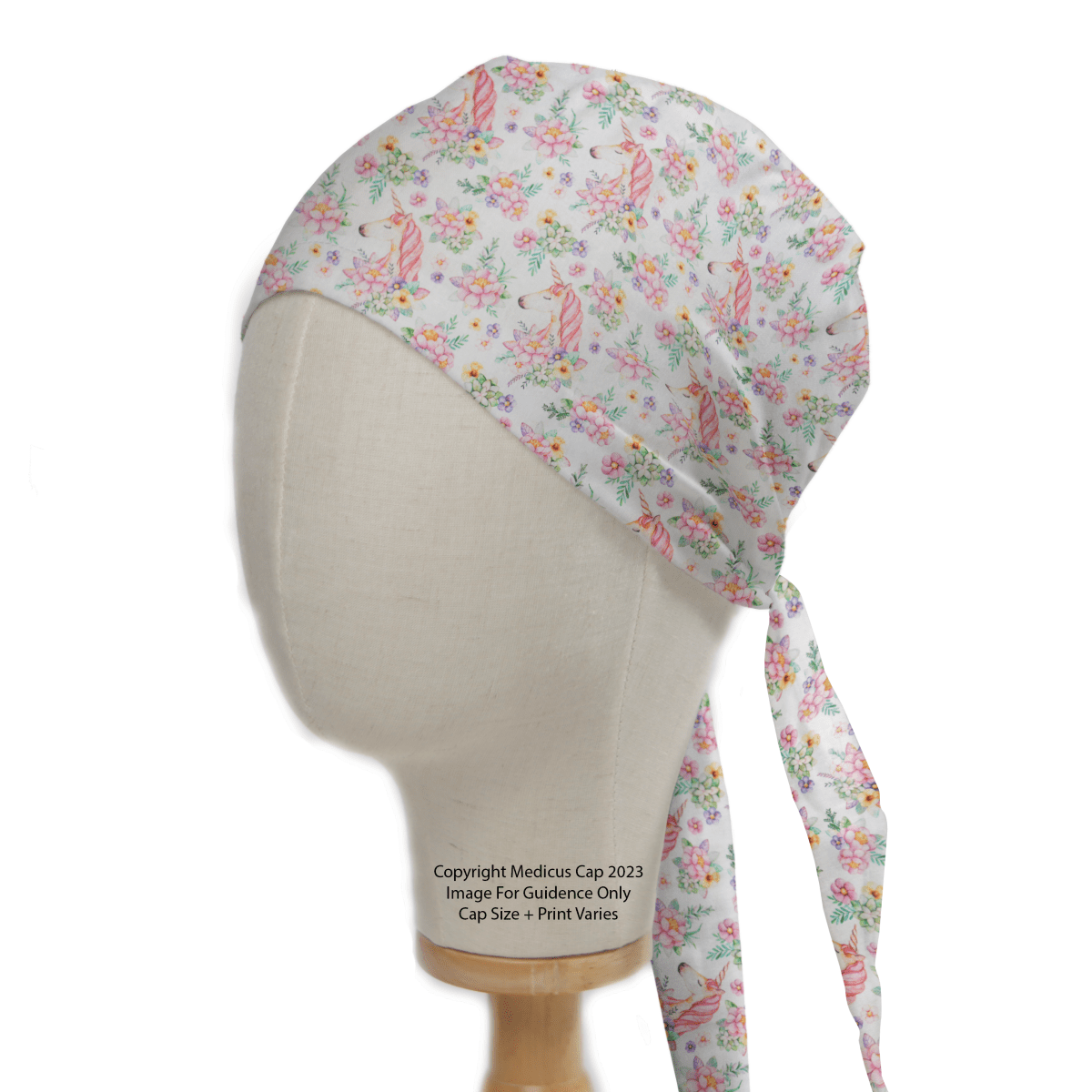 Unicorns Flower Power Scrub Cap by Medicus Scrub Caps: A floral-patterned fabric cap on a mannequin, featuring pink and green flowers with ribbon-like designs on white. The elegant ties hang down the side, blending style and whimsy in sustainable healthcare fashion.