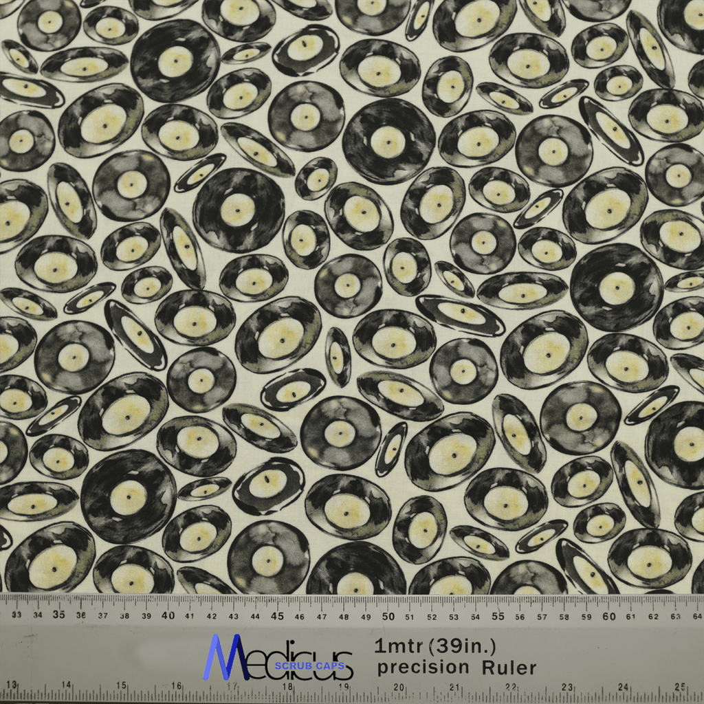 The Medicus Scrub Caps Vinyl Discs Scrub Cap fabric displays black vinyl records on a light background, perfect for music lovers. A ruler with inches and centimeters at the bottom aids crafting in sustainable healthcare settings.