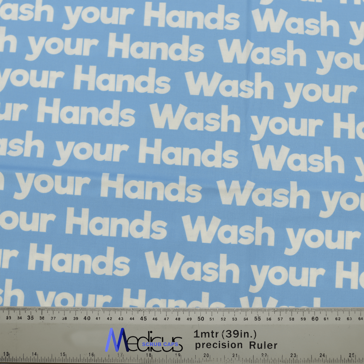 The blue Wash Your Hands scrub cap, featuring repeated white text, is perfect for a sustainable healthcare environment. Its ideal for crafting with accurate measurements shown by a ruler at the bottom edge. Made by Medicus Scrub Caps.