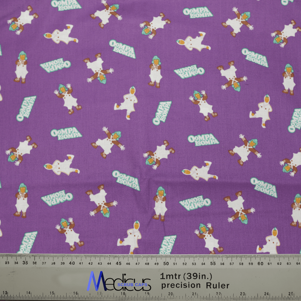 The Medicus Scrub Caps Willy Wonka Oompa Loompa features colorful Willy Wonka character illustrations and Ompa Loompa text on purple fabric. A ruler at the bottom highlights its whimsical design, ideal for crafting scrub caps.
