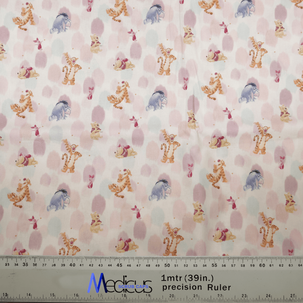 The Medicus Scrub Caps Winnie The Pooh + Friends Finger Paint features a playful pattern with cartoon tigers, elephants, and bears on white, adorned with pink polka dots. A ruler is at the bottom edge for scale.