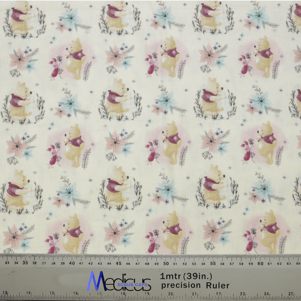 Woodland-themed fabric adorned with bears, foxes, and rabbits amidst colorful flowers on a light backdrop is ideal for crafting the Winnie The Pooh + Piglet Scrub Cap by Medicus Scrub Caps. Includes a ruler for measurements in meters and inches.