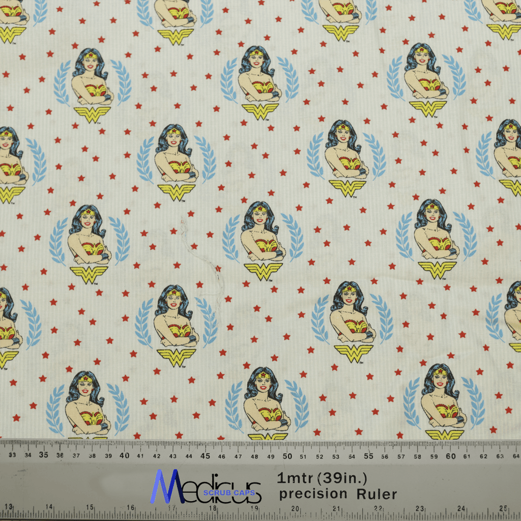 The Wonder Woman Crest Scrub Cap by Medicus Scrub Caps features a comic-style superhero woman with the Wonder Woman crest, red stars, and measurements in inches and centimeters along the bottom—ideal for healthcare professionals seeking style.