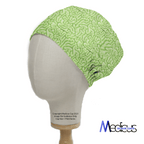 The mannequin head features the eco-friendly Zombie Brain Green Scrub Cap by Medicus Scrub Caps, showcasing a detailed brain fold pattern. Ideal for healthcare pros, copyright info and details on size and print variation are provided below.