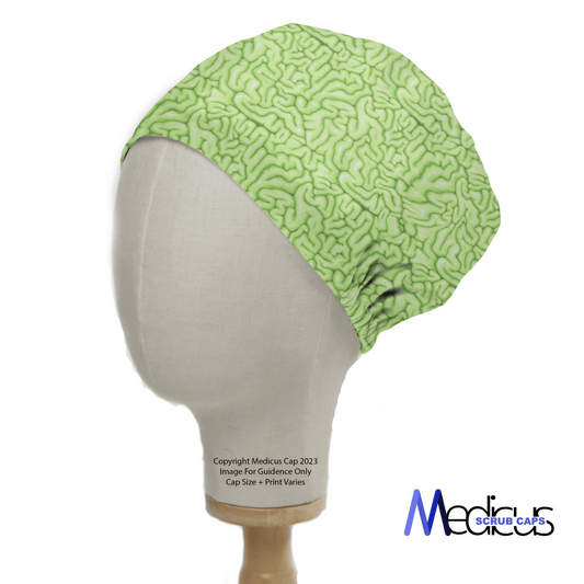 The mannequin head features the eco-friendly Zombie Brain Green Scrub Cap by Medicus Scrub Caps, showcasing a detailed brain fold pattern. Ideal for healthcare pros, copyright info and details on size and print variation are provided below.