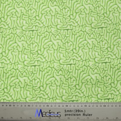 A close-up of Medicus Scrub Caps Zombie Brain Green Scrub Cap fabric, featuring an abstract squiggly pattern. A ruler below displays centimeters and inches alongside Medicus, appealing to healthcare professionals interested in eco-friendly options.